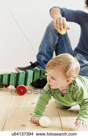 Studio shot of father and baby daughter playing on floor View Large Photo Image Picture - Studio shot of father and baby daughter playing on floor. Fotosearch
