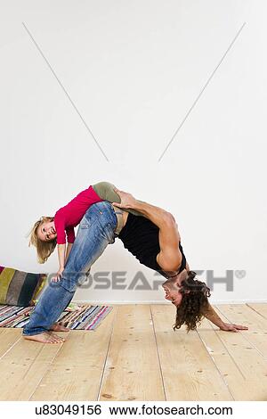 Stock Photograph - Studio shot of father with daughter bending over on floor. Fotosearch