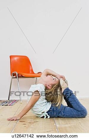 Stock Image - Studio shot of girl bending backwards with feet on head. Fotosearch