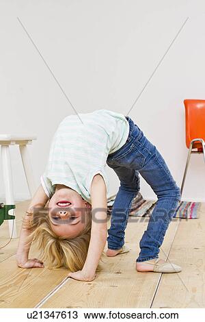 Stock Image - Studio shot of girl bending backwards doing the crab. Fotosearch