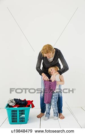 Studio shot of mother and daughter with dirty laundry View Large Photo Image Stock Photo - Studio shot of mother and daughter with dirty laundry. Fotosearch