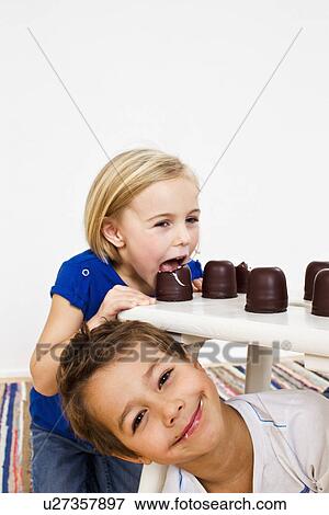 Studio shot of sister and brother with chocolate marshmallows View Large Photo Image Stock Photo - Studio shot of sister and brother with chocolate marshmallows. Fotosearch