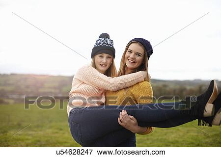 Teenage girl being lifted up by best friend View Large Photo Image Stock Photo - Teenage girl being lifted up by best friend. Fotosearch