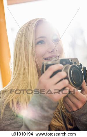 Picture - Teenage girl holding camera. Fotosearch