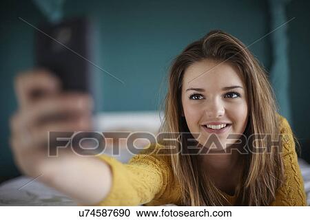 Teenage Girl In Bedroom Taking A Selfie Stock Image