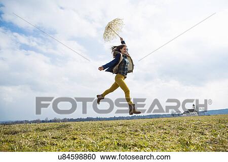 Teenage girl in field with umbrella View Large Photo Image Stock Image - Teenage girl in field with umbrella. Fotosearch