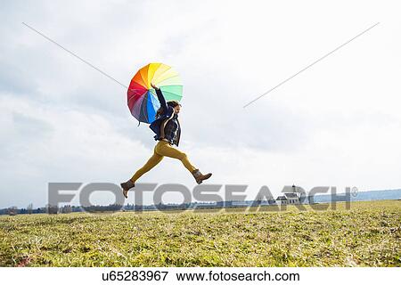 Teenage girl in field with umbrella View Large Photo Image Stock Photo - Teenage girl in field with umbrella. Fotosearch