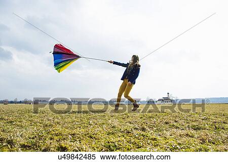 Stock Photography - Teenage girl in field with umbrella. Fotosearch