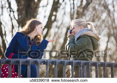 Teenage girl photographing friend with camera View Large Photo Image Stock Photo - Teenage girl photographing friend with camera. Fotosearch