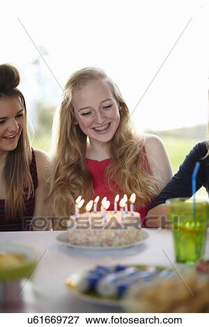 Stock Photo - Teenage girl with birthday cake and candles. Fotosearch