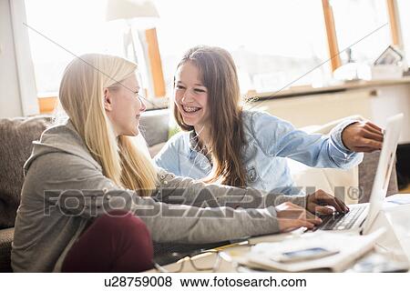 Teenage girls using laptop at home View Large Photo Image Stock Photo - Teenage girls using laptop at home. Fotosearch