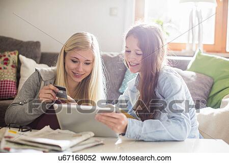 Stock Image - Teenage girls using tablet for online shopping. Fotosearch