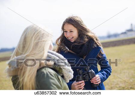 Stock Image - Teenage girls with binoculars. Fotosearch