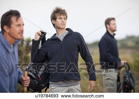 Three men hiking in rural landscape View Large Photo Image Stock Image - Three men hiking in rural landscape. Fotosearch