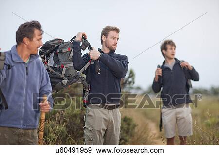 Three men hiking with backpacks View Large Photo Image Stock Photo - Three men hiking with backpacks. Fotosearch