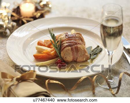 Turkey parcel wrapped in pancetta, stuffed with cranberry and orange and served with lemon and sage sauce with roasted winter vegetables, amid festive decorations View Large Photo Image Stock Image - Turkey parcel wrapped in pancetta, stuffed with cranberry and orange and served with lemon and sage sauce with roasted winter vegetables, amid festive decorations. Fotosearch