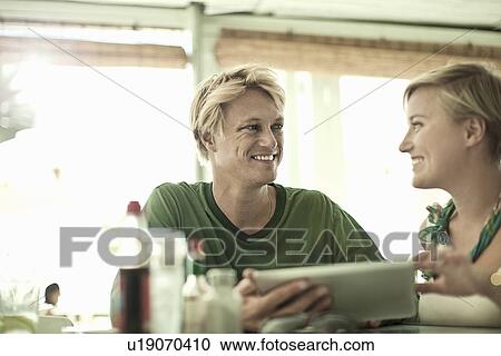 Two couple using digital tablet in cafe bar View Large Photo Image Stock Image - Two couple using digital tablet in cafe bar. Fotosearch