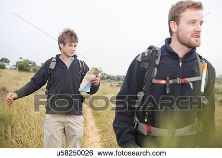 Stock Photograph - Two male hikers with backpacks and map. Fotosearch