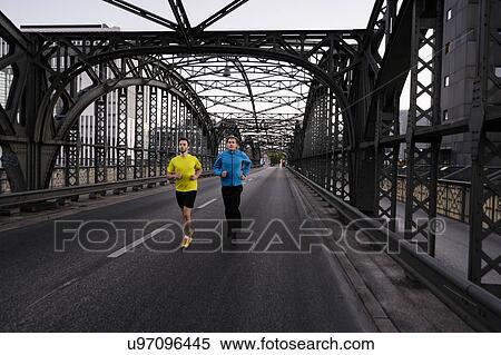 Two men running over city bridge View Large Photo Image Stock Photography - Two men running over city bridge. Fotosearch