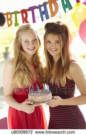 Two teenage girls holding birthday cake View Large Photo Image Stock Image - Two teenage girls holding birthday cake. Fotosearch