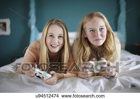 Two teenage girls playing on computer game in bedroom View Large Photo Image Picture - Two teenage girls playing on computer game in bedroom. Fotosearch