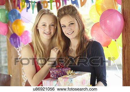 Two teenage girls sharing gifts at birthday party View Large Photo Image Stock Photograph - Two teenage girls sharing gifts at birthday party. Fotosearch