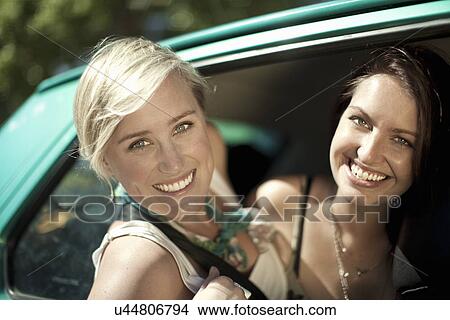 Two young woman leaning from car window View Large Photo Image Picture - Two young woman leaning from car window. Fotosearch