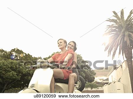 Stock Photo - Two young women on moped. Fotosearch