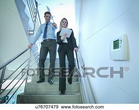 View of thermostat in office stairwell with workers walking down stairs View Large Photo Image Stock Photo - View of thermostat in office stairwell with workers walking down stairs. Fotosearch