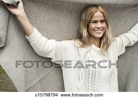 Picture - Woman holding blanket over head. Fotosearch