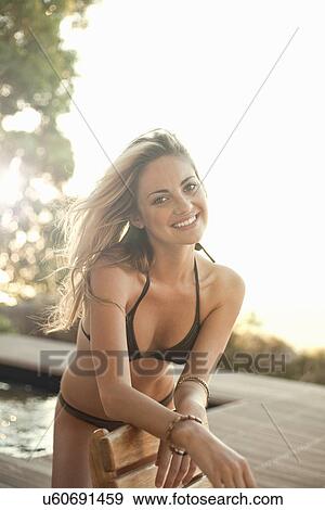Woman in bikini posing by pool View Large Photo Image Stock Photo - Woman in bikini posing by pool. Fotosearch