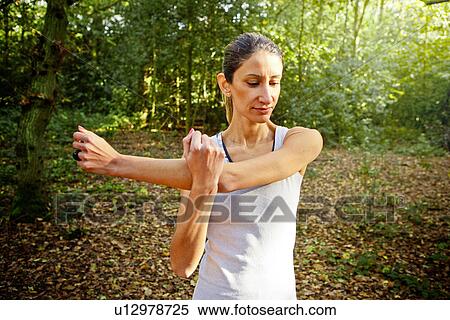 Woman stretching arms in woods View Large Photo Image Stock Photography - Woman stretching arms in woods. Fotosearch