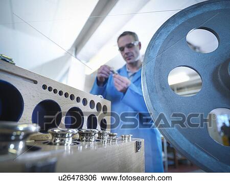 Stock Photograph - Worker calibrating equipment for automotive use, close up. Fotosearch