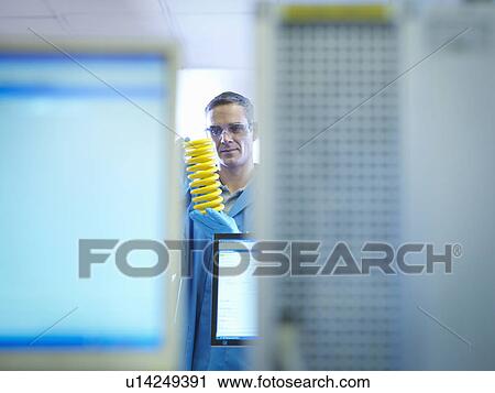 Worker holding and testing yellow spring View Large Photo Image Stock Image - Worker holding and testing yellow spring. Fotosearch