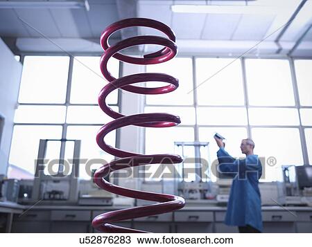 Worker inspecting spring in laboratory, focus on foreground View Large Photo Image Stock Image - Worker inspecting spring in laboratory, focus on foreground. Fotosearch