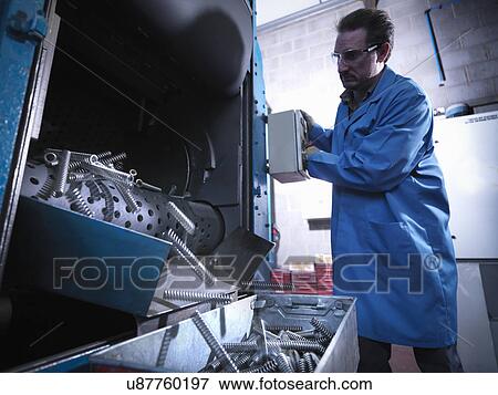 Worker shot blasting springs in laboratory View Large Photo Image Stock Photo - Worker shot blasting springs in laboratory. Fotosearch