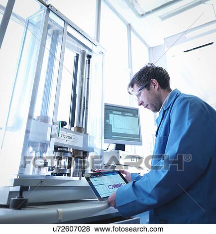 Worker using digital tablet to test spring in laboratory View Large Photo Image Stock Photo - Worker using digital tablet to test spring in laboratory. Fotosearch