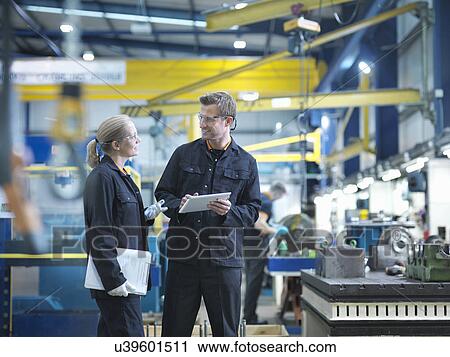 Workers in discussion in engineering factory View Large Photo Image Stock Image - Workers in discussion in engineering factory. Fotosearch