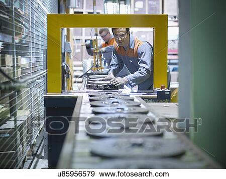Workers on production line in industrial clutch factory View Large Photo Image Stock Photo - Workers on production line in industrial clutch factory. Fotosearch