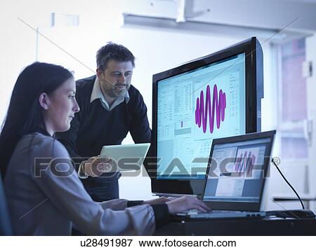 Workers using software to calibrate springs in office View Large Photo Image Stock Photo - Workers using software to calibrate springs in office. Fotosearch