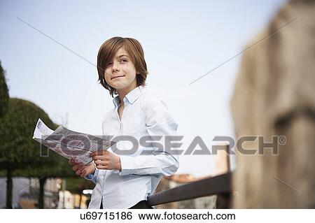 Stock Photograph - Young boy looking at map in park, Province of Venice, Italy. Fotosearch