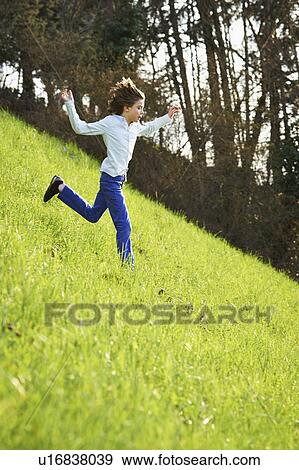 Young boy running down steep grassy field View Large Photo Image Stock Photo - Young boy running down steep grassy field. Fotosearch