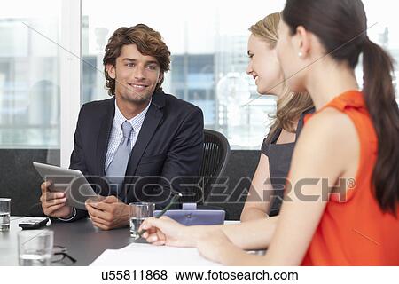 Stock Photo - Young business colleagues meeting in office. Fotosearch