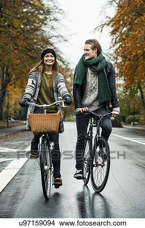 Picture - Young couple cycling on street. Fotosearch