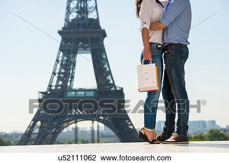 Young couple embracing in front of Eiffel Tower, Paris, France View Large Photo Image Stock Image - Young couple embracing in front of Eiffel Tower, Paris, France. Fotosearch