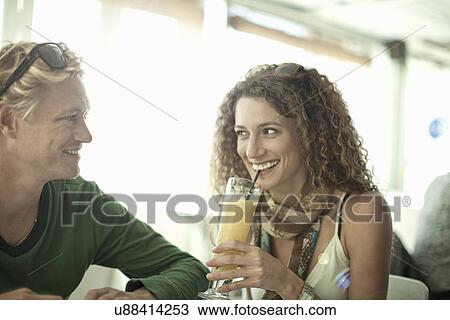 Young couple enjoying drinks in cocktail bar View Large Photo Image Stock Image - Young couple enjoying drinks in cocktail bar. Fotosearch