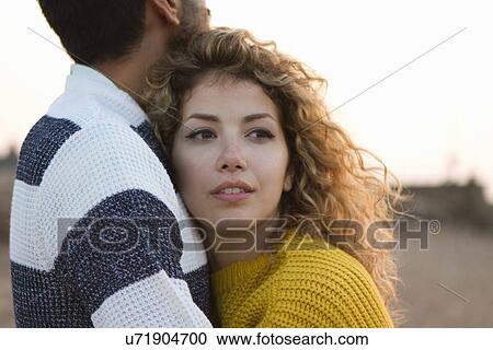 Stock Image - Young couple hugging on beach. Fotosearch