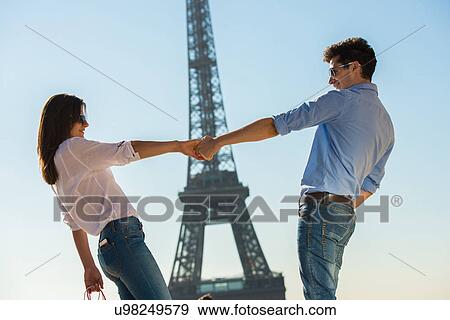 Stock Photo - Young couple in front of Eiffel Tower, Paris, France. Fotosearch