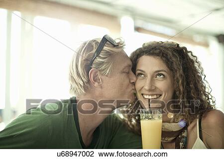 Young couple kissing in cocktail bar View Large Photo Image Stock Image - Young couple kissing in cocktail bar. Fotosearch