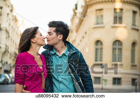 Stock Image - Young couple kissing on street, Paris, France. Fotosearch